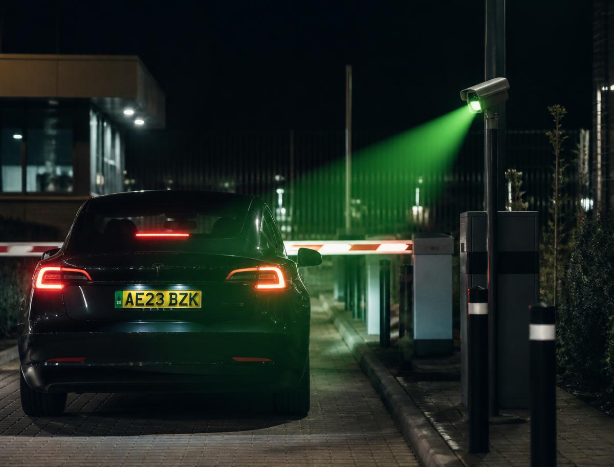 Car at a barrier at night with its number plate being read by an ANPR camera